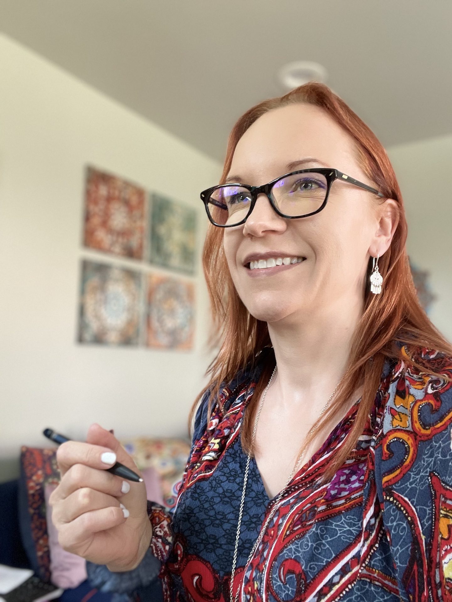 Kirsi Bromann holding a pen and wearing glasses